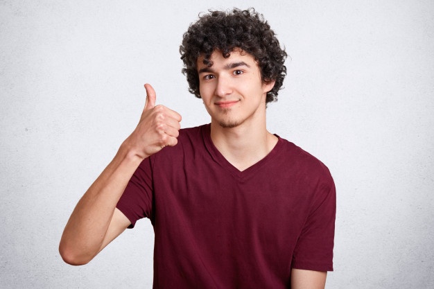 curly hair boy giving thumbs up