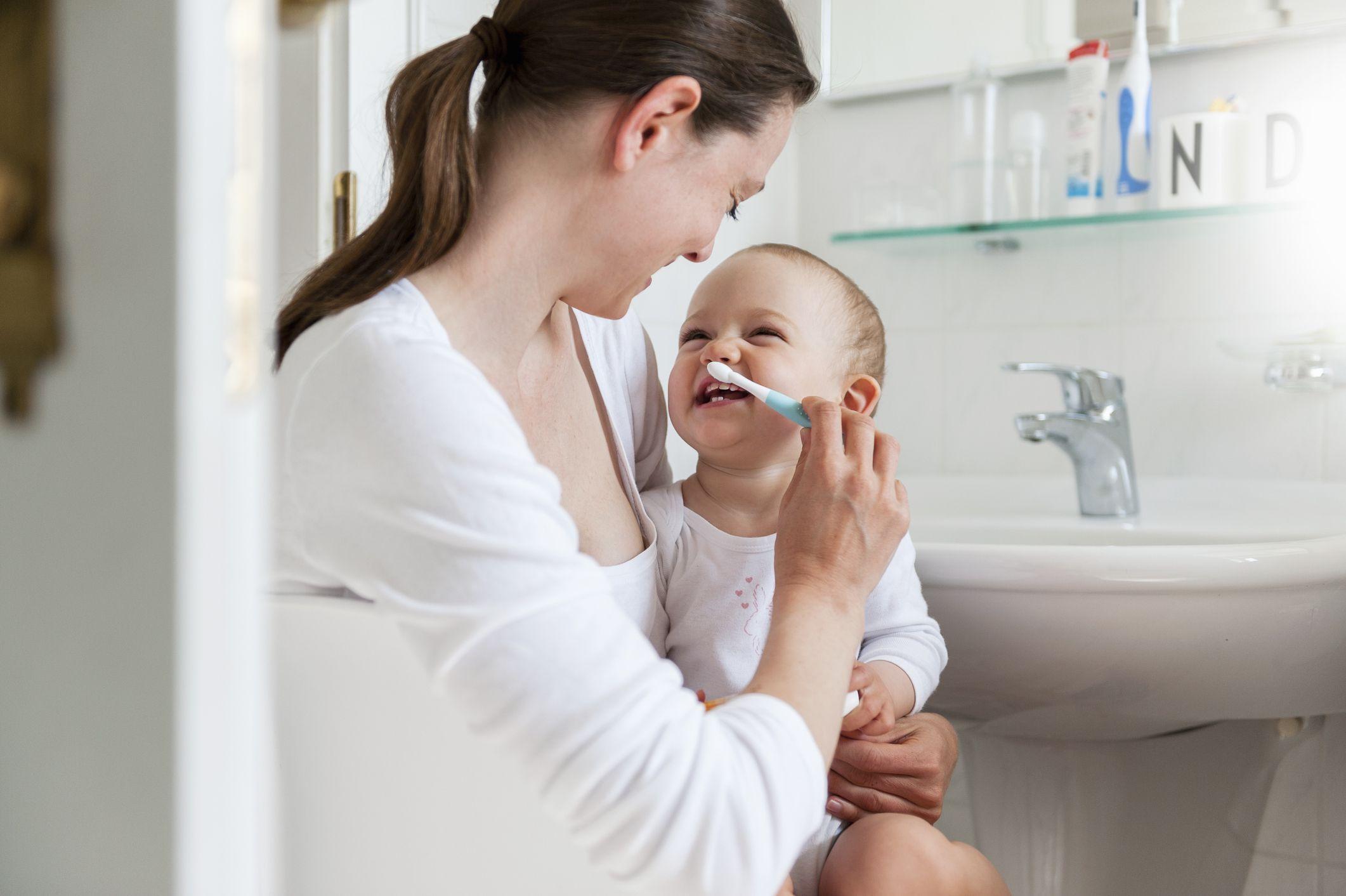 Mom brushing kids teeth